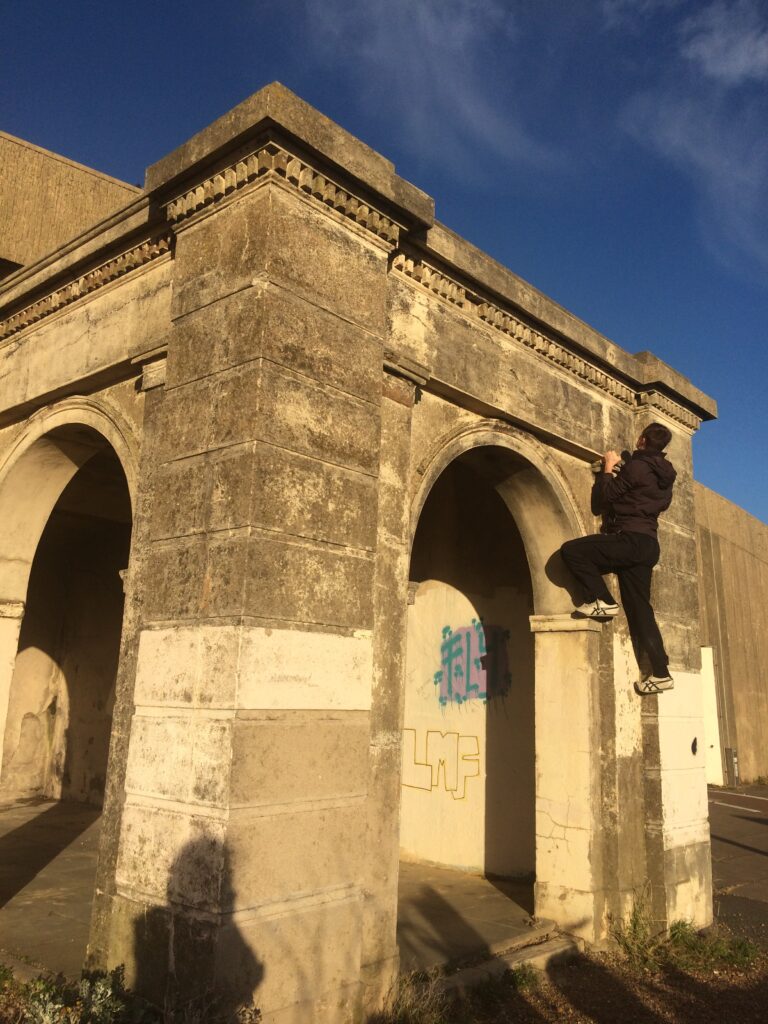 Alex climbing the side of a small building