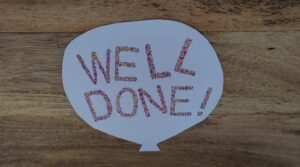 a handmade card saying 'well done!'