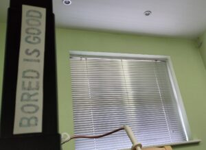 a photo of a closed window with a sign saying 'bored is good'